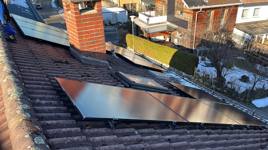Solaranlage auf Hausdach mit Hecken im Vorgarten